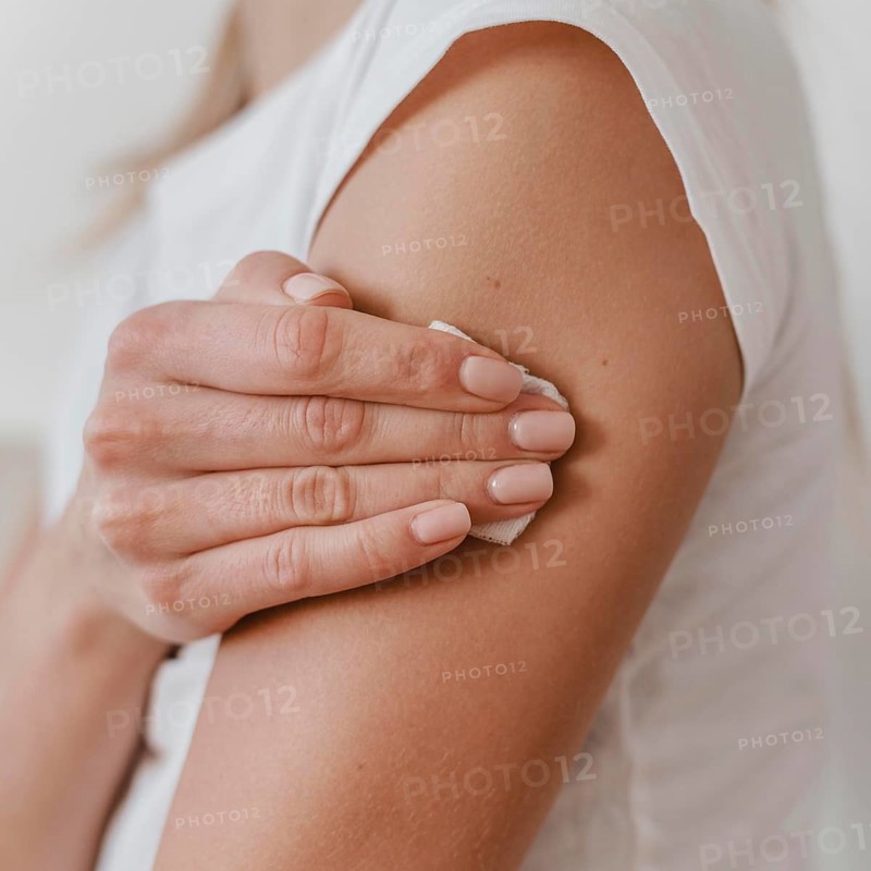 Side view woman holding her arm after getting her vaccine