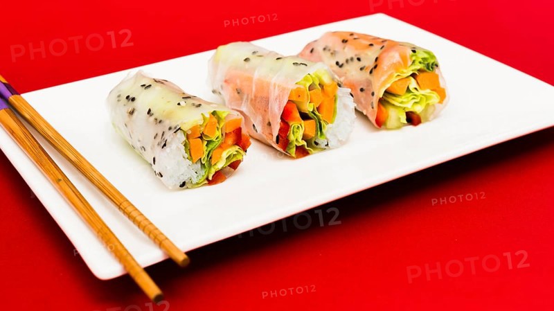 Steamed spring rolls arrange white plate with chopstick red surface