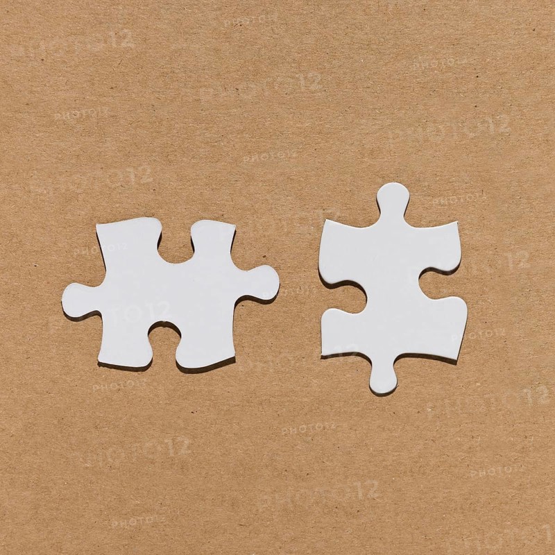 White jigsaw puzzle piece brown paper textured backdrop