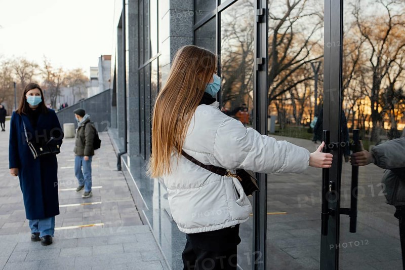 Woman with mask opening door