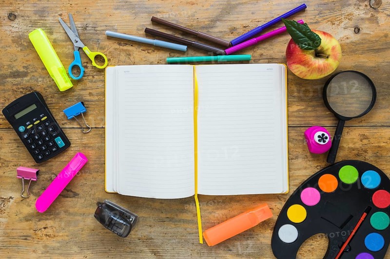 Writing implements apple laid circle with notebook middle