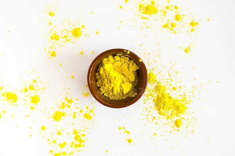 Yellow holi color powder bowl white background