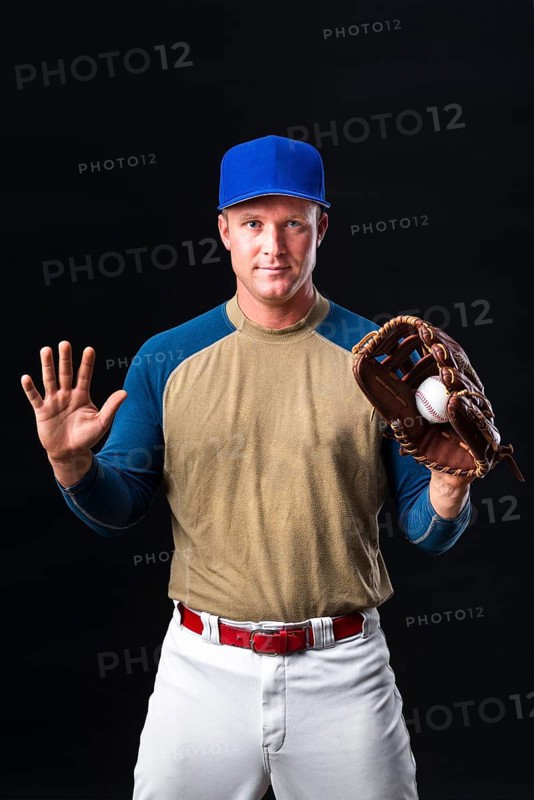Baseball player with cap posing with glove