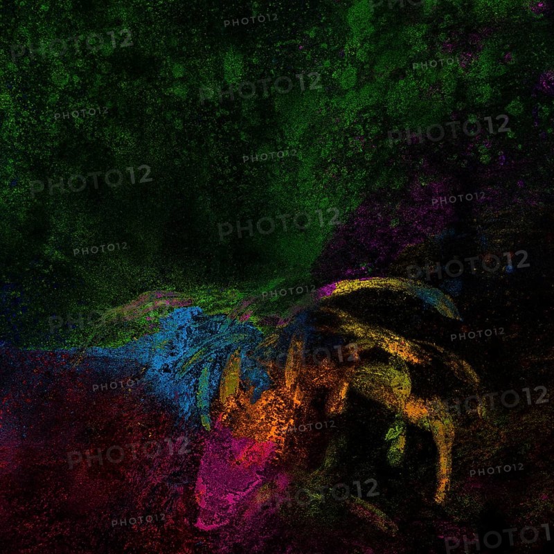 Bright rangoli colors spread black surface