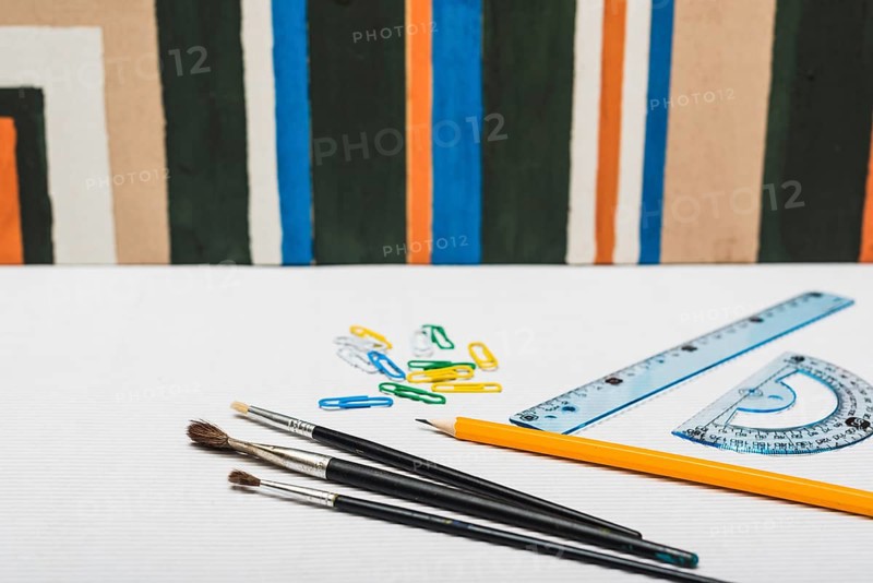Brushes stationery near abstract painting