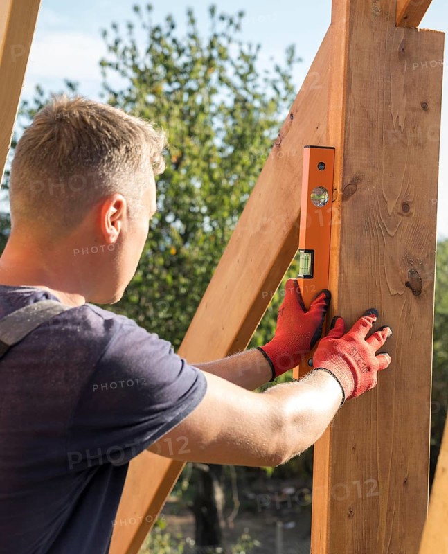 Carpenter man taking measures wood plank