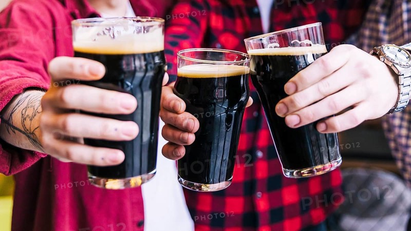 Close up friends clinking beer glasses