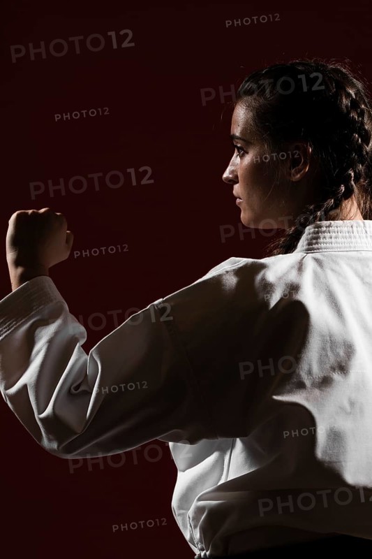 Close up sideways woman white karate uniform