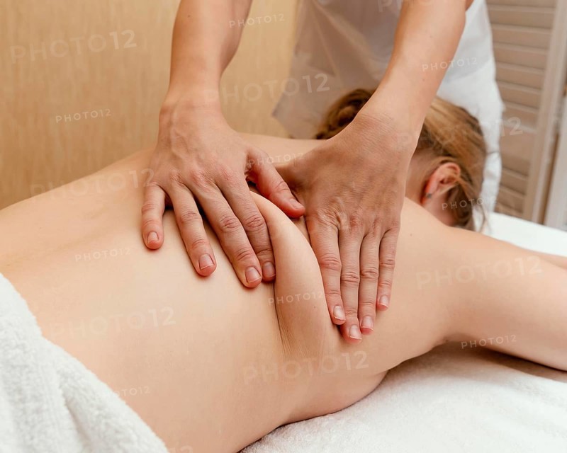 Close up therapist massaging woman s back