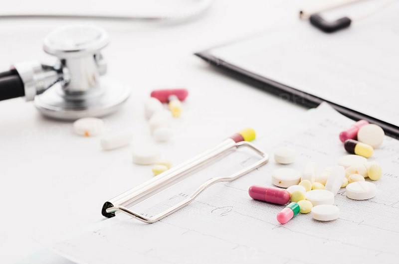 Colorful pills ecg graph stethoscope white background