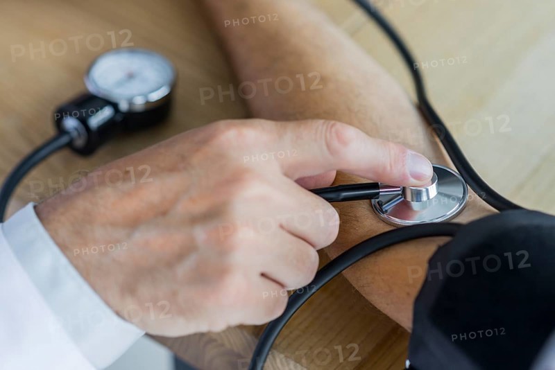 Crop hand measuring blood pressure patient
