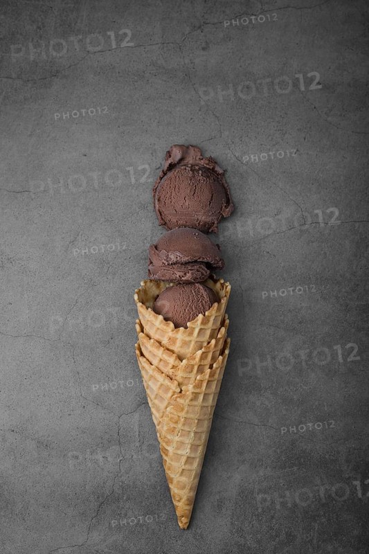 Flat lay cone with three scoops chocolate ice cream