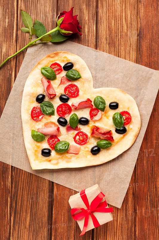 Flat lay heart shaped pizza wooden table