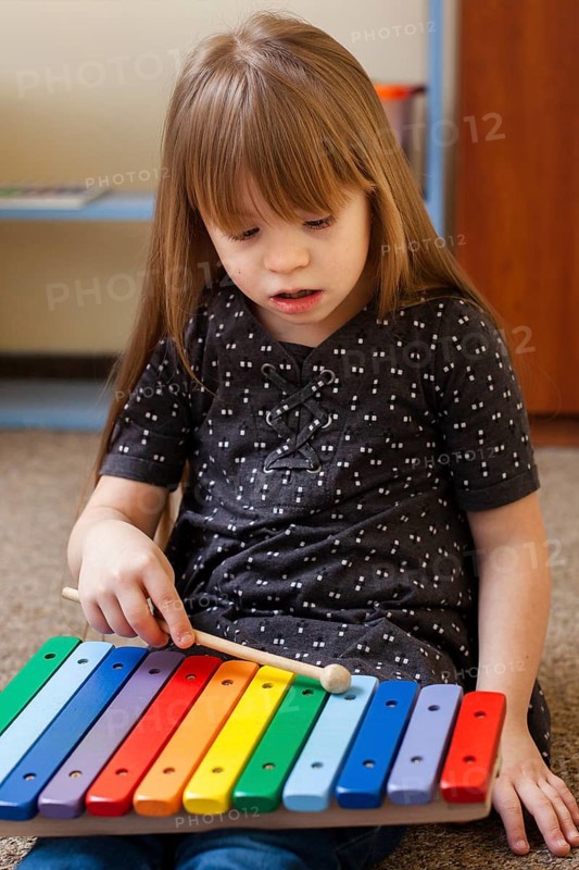Girl with down syndrome playing with xylophone