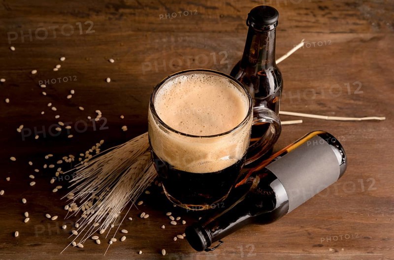Glass beer foam with brown bottles beer wooden table