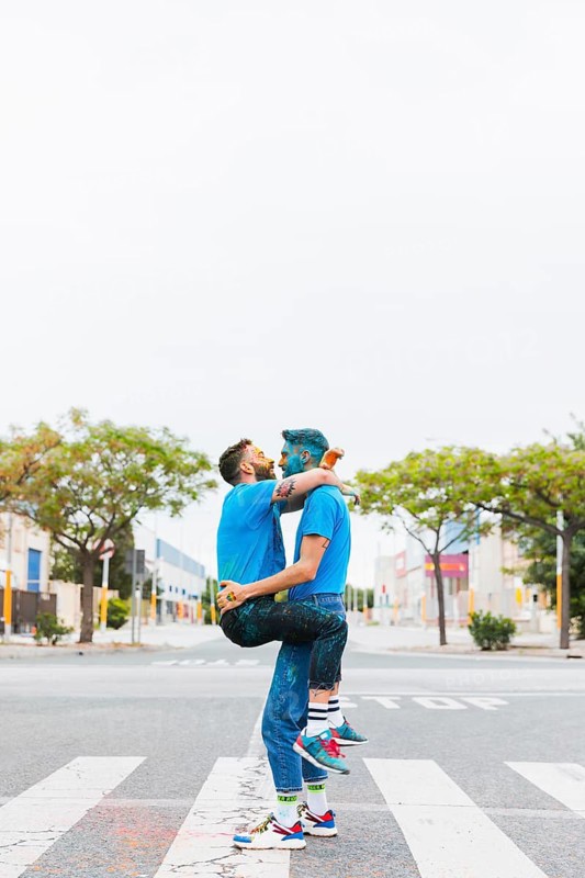 Homosexual couple hugging holi festival
