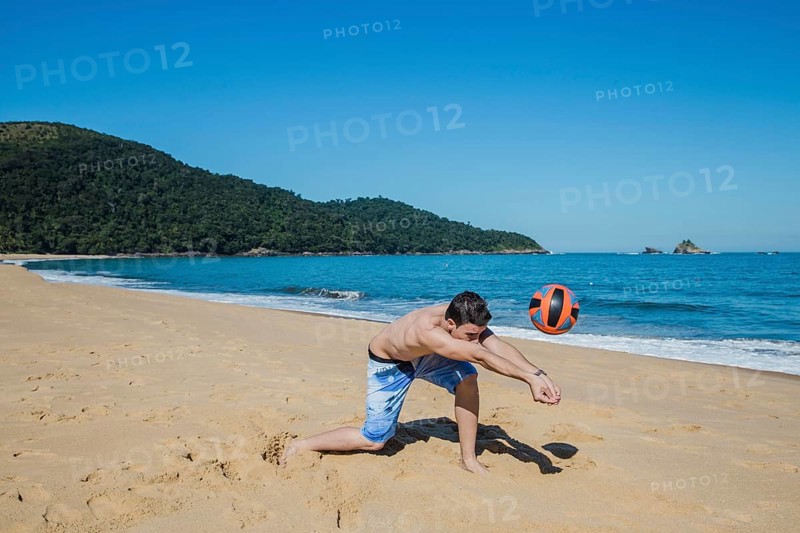 Man playing volleyball shoreline