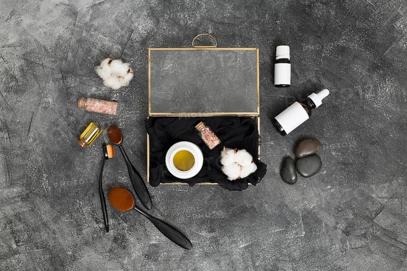 Open box with honey pink himalayan salt cotton bud with cosmetics products concrete black background