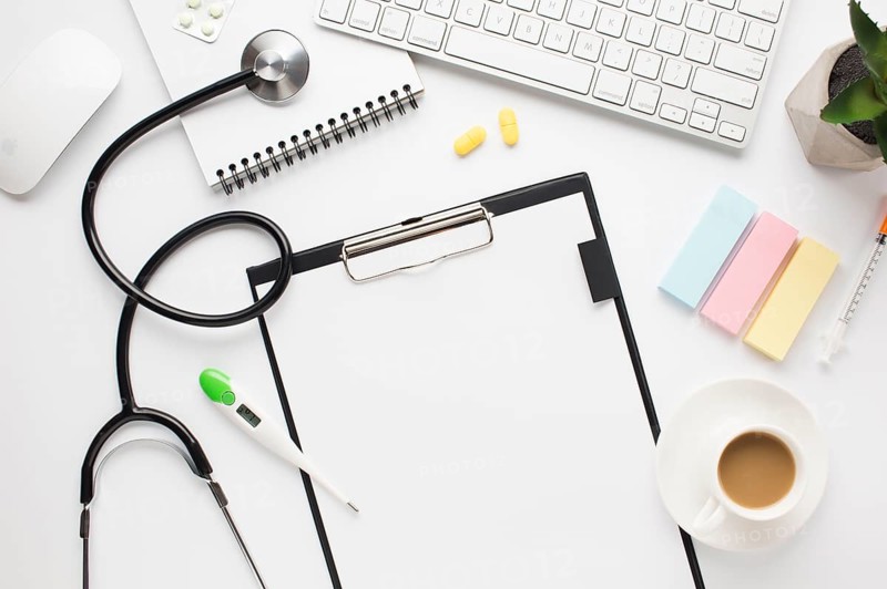 Overhead view medical desk with coffee cup adhesive notes table