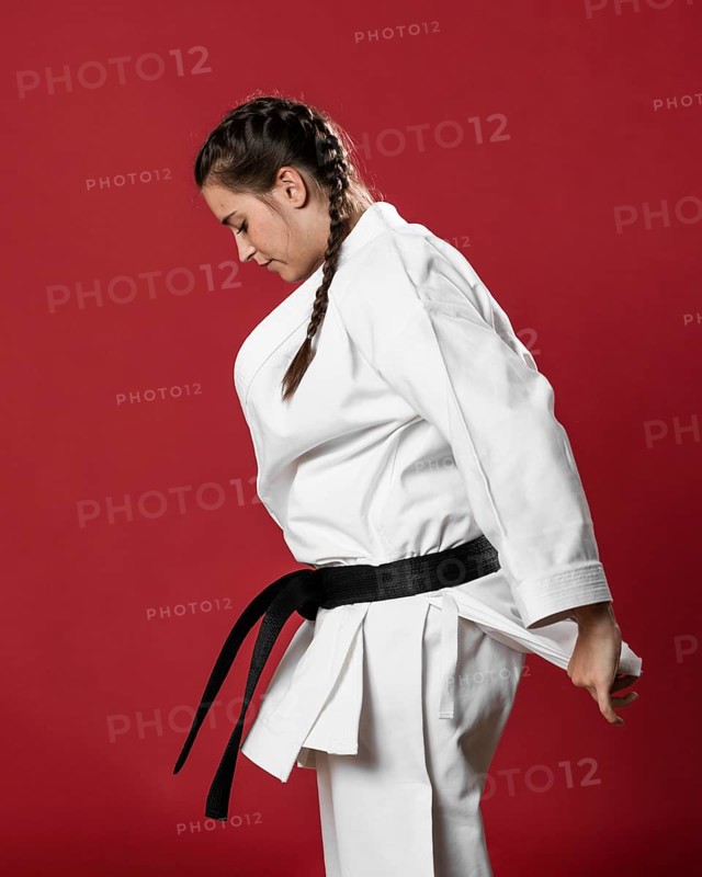 Sideways karate woman traditional white kimono red background