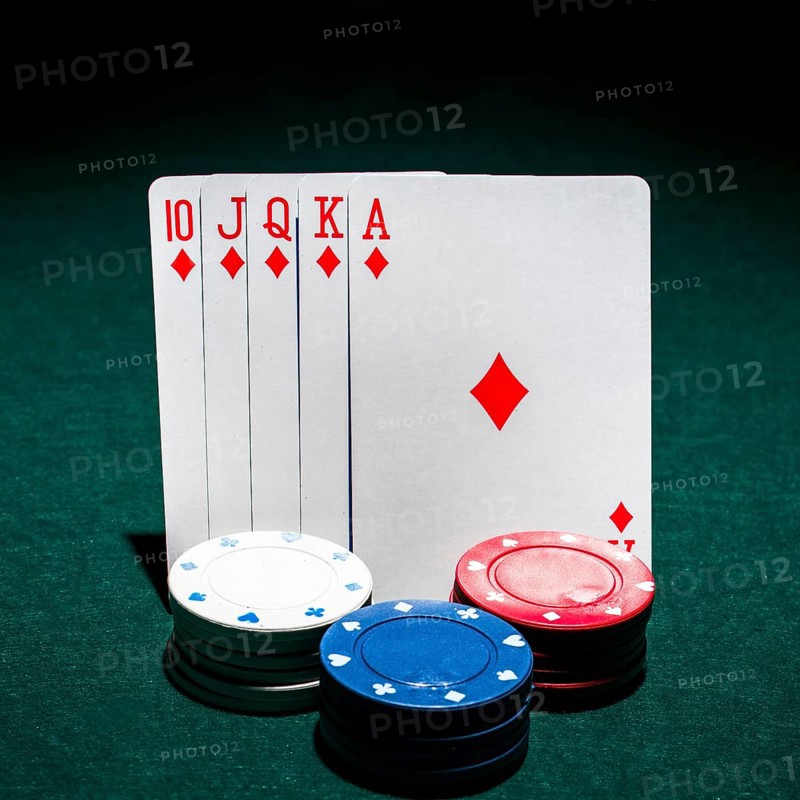 Stack casino chips front royal flush playing card poker table