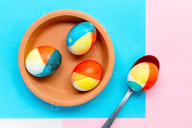 Top view colored eggs easter plate with spoon