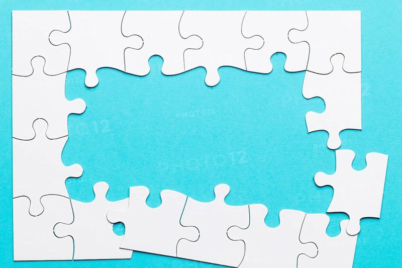 Top view incomplete puzzle frame blue backdrop