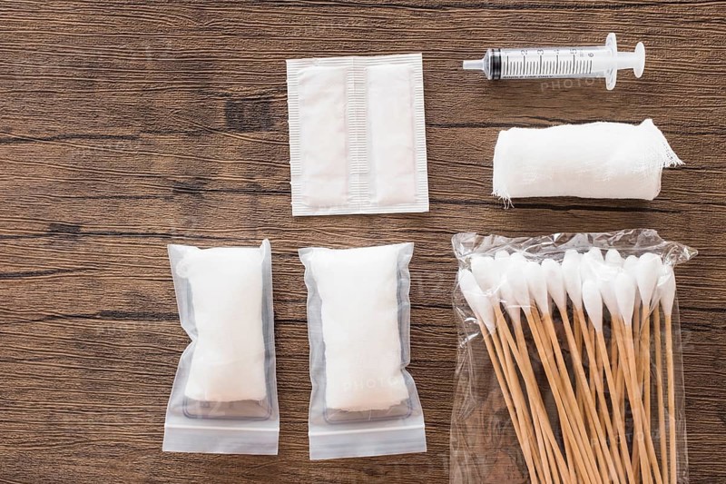 White medical cotton gauze bandage syringe pack cotton swab wooden table