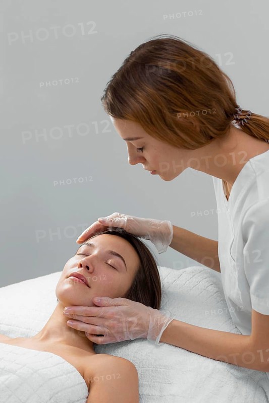 Beautician with female client salon face care routine 5