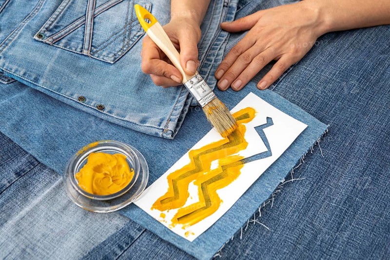 Close up hand painting jeans