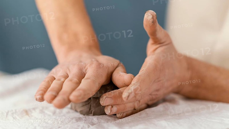 Close up hands shaping clay