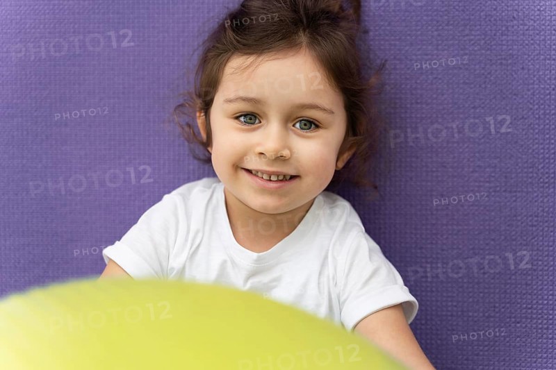 Close up smiley kid holding gym ball
