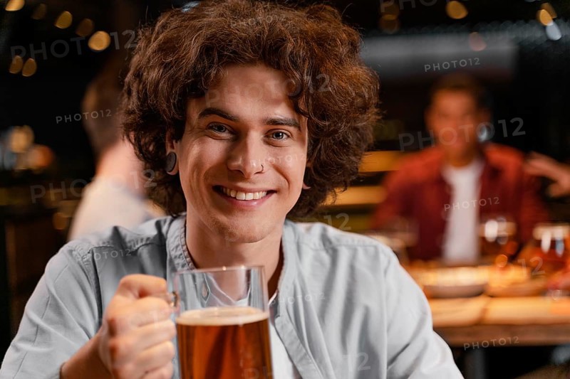 Close up smiley man holding beer mug pub