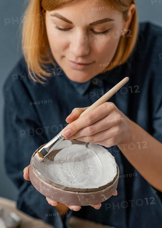 Close up woman painting clay