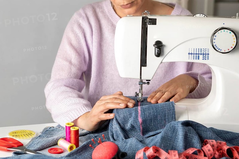 Close up woman sewing with machine