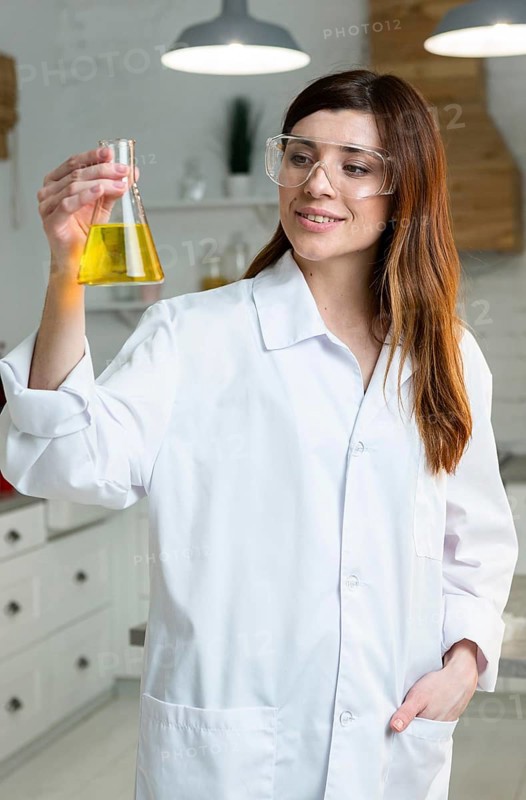 Front view female scientist with safety glasses holding test tube