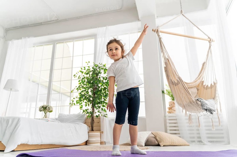Full shot girl standing yoga mat