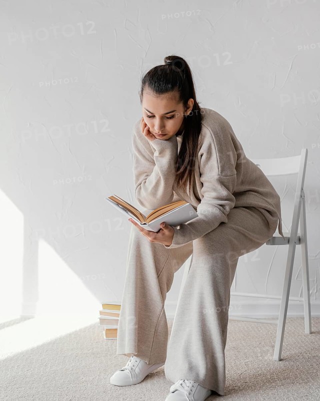 Full shot woman chair reading