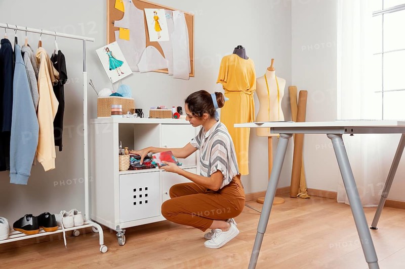 Full shot woman holding fabrics