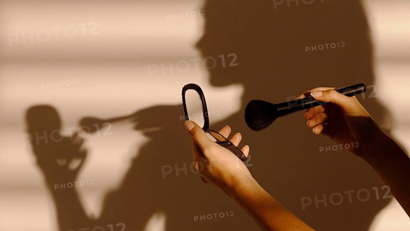 Shadow woman using different cosmetics