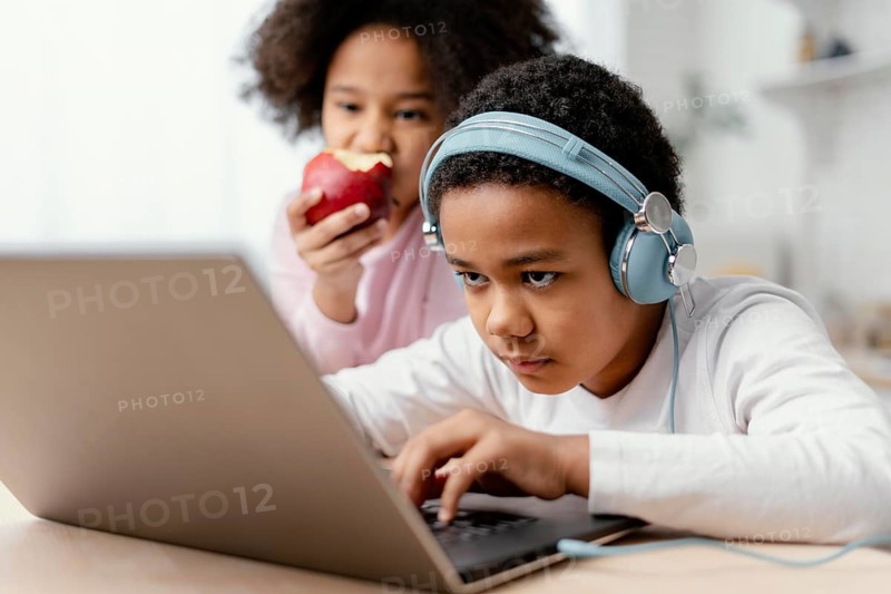 Siblings listening music using laptop