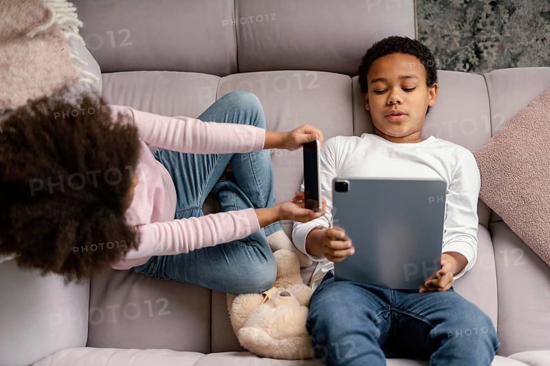 Siblings using tablet mobile home 4