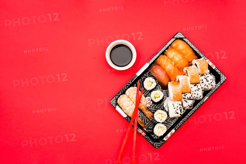 Sushi rolls sashimi tray with soy sauce colored background