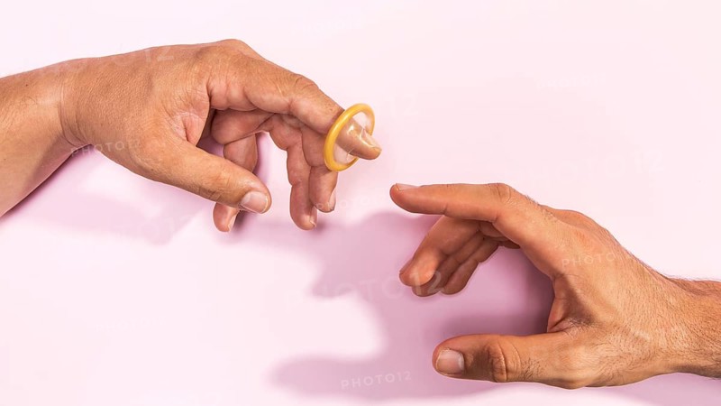 Close up man hands with transparent condom