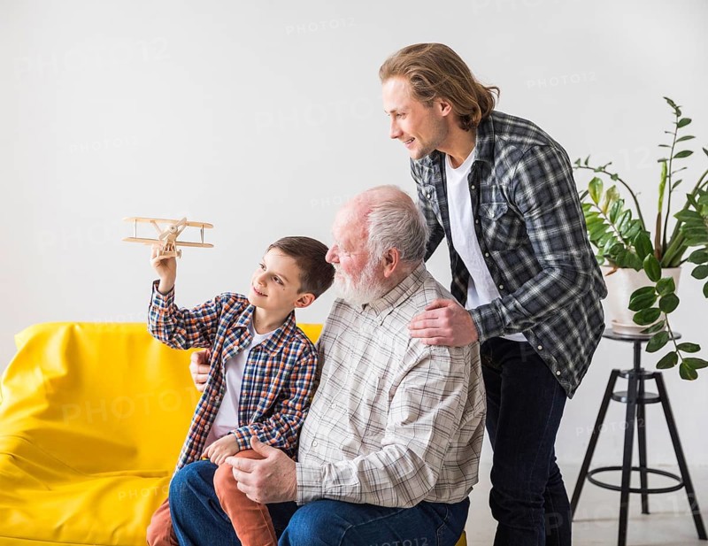 Men different generations looking toy plane