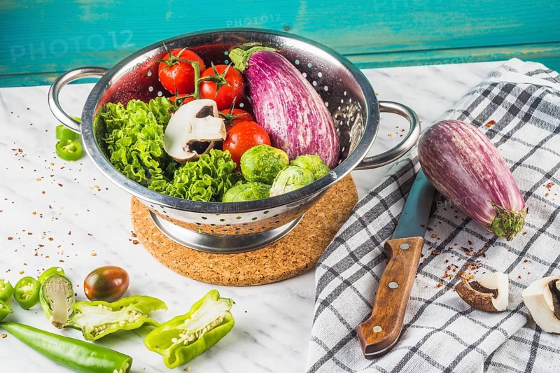 Various fresh vegetables colander marble surface
