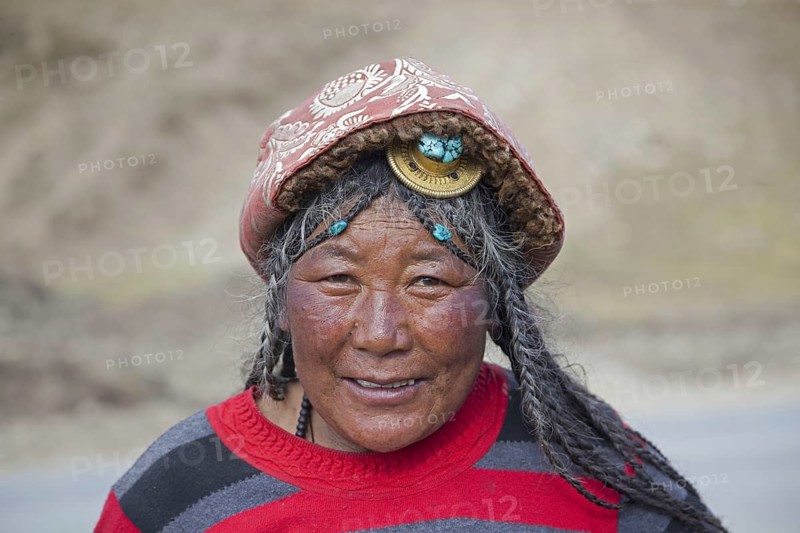Portrait of Tibetan Khampa woman wearing traditional amber hair piece at Zhuqing
