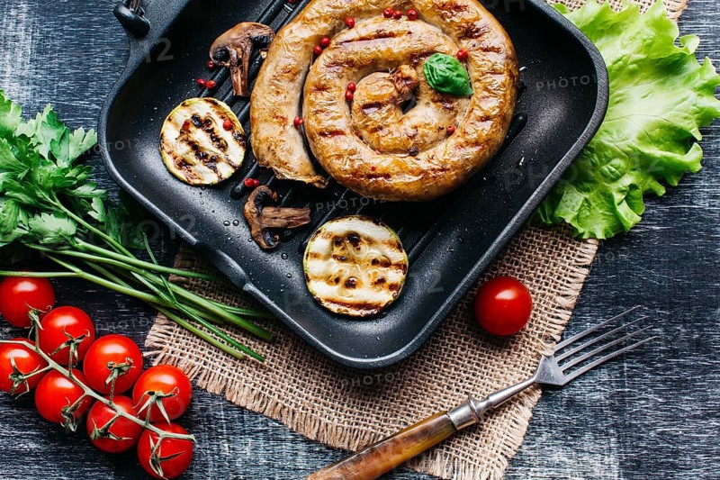Grill pan with delicious spiral grilled sausage vegetable