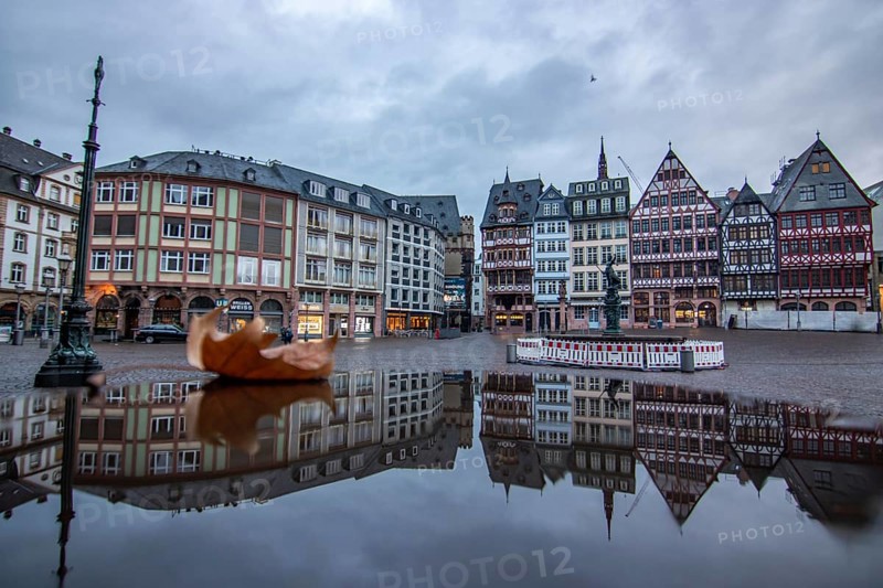 Reflection in a puddle between a historic city centre. Cityscape at the Roemer and the historic houses and streets. Cityscape in Frankfurt am Main