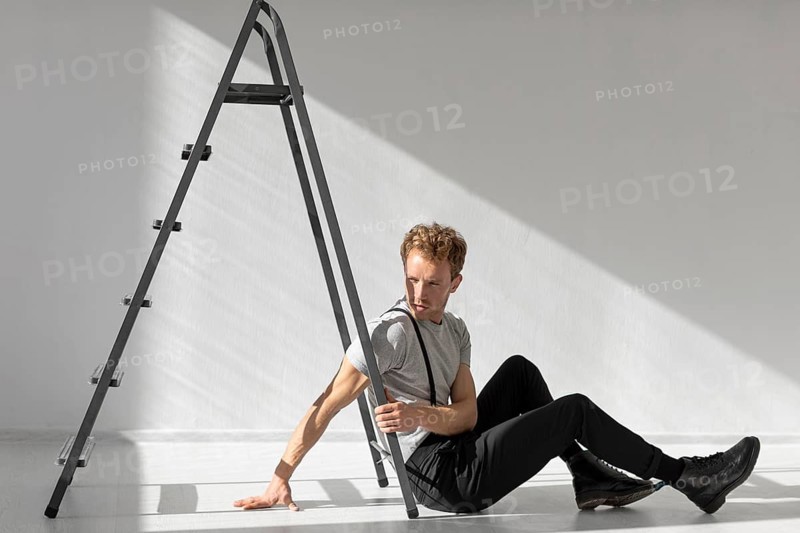 Sideways man sitting floor ladder